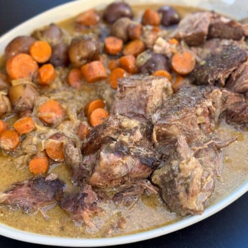 platter of bison chuck roast recipe with gravy, carrots, and potatoes