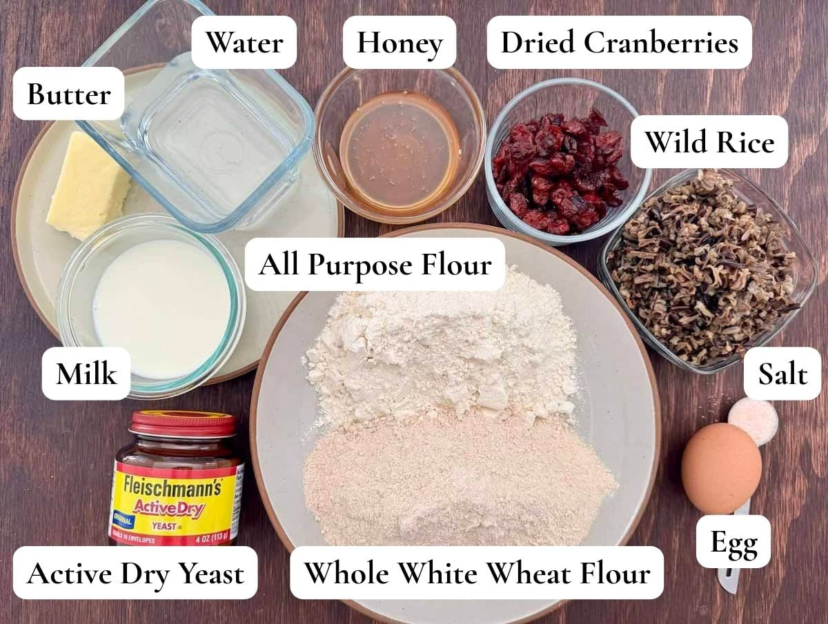The ingredients for cranberry wild rice bread portioned and displayed on a wooden table top.