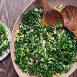 overhead view of chick fil a kale salad with wooden salad tongs