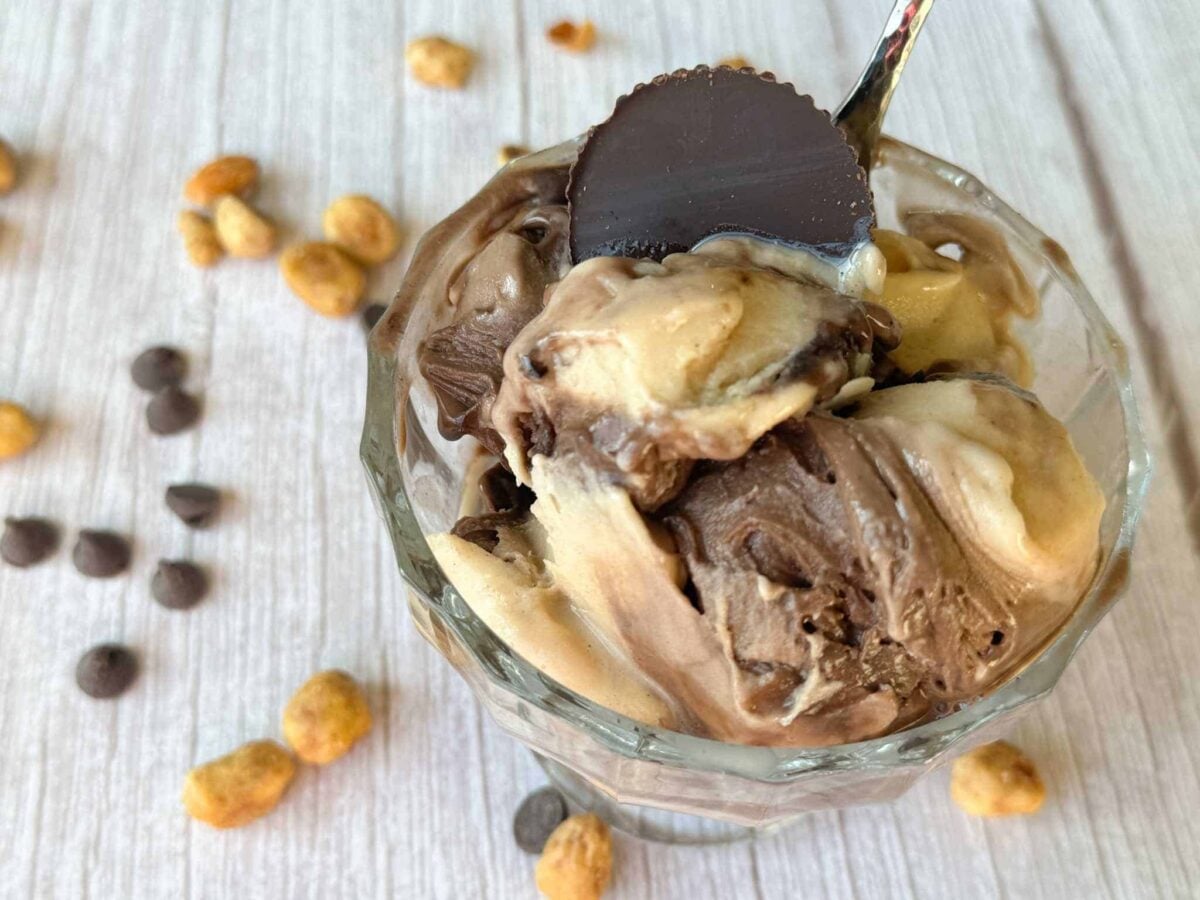dish of Ninja Creami chocolate peanut butter swirl with peanuts & chocolate chips in the background.