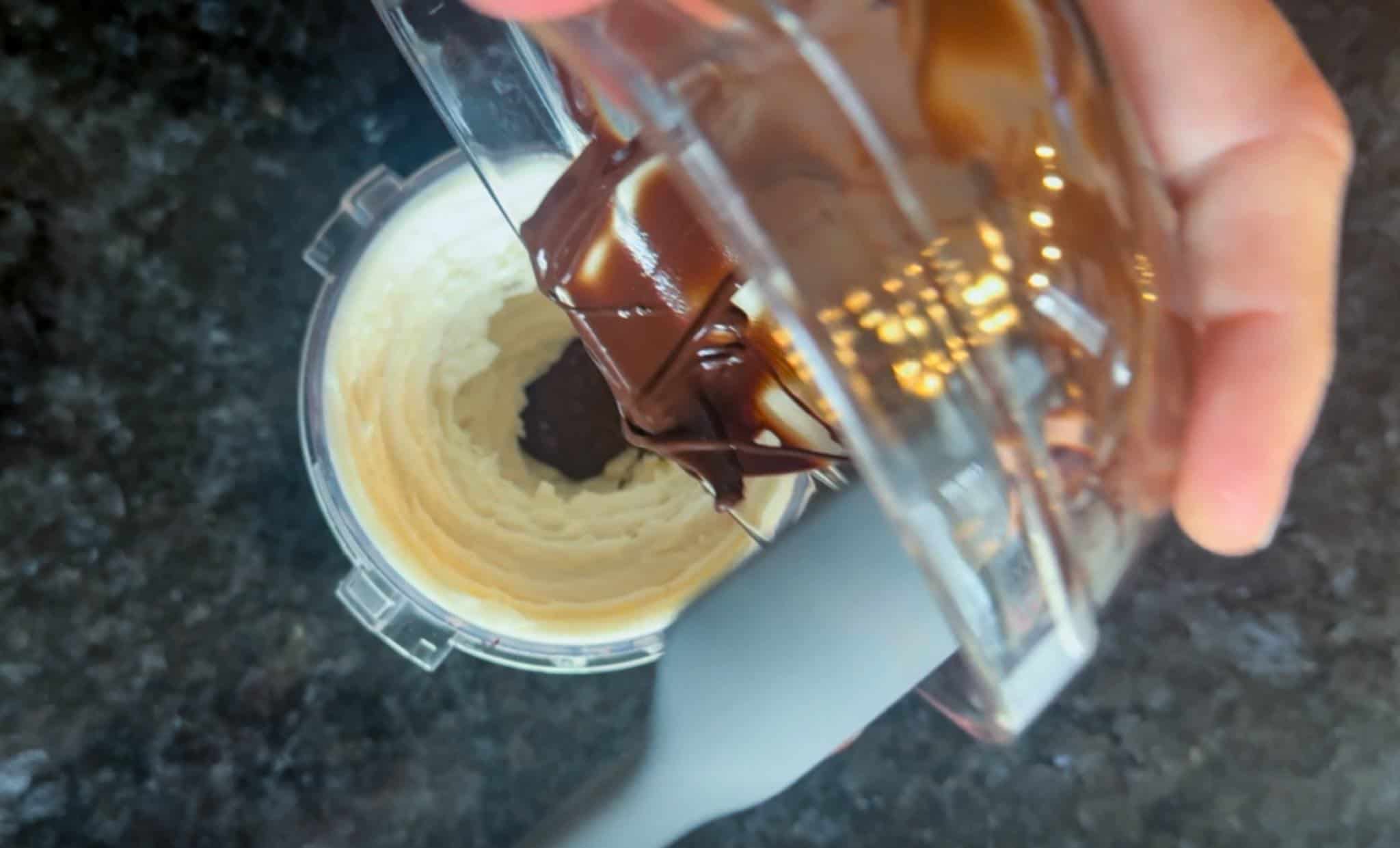 Pouring melted chocolate into the Ninja Creami pint container.