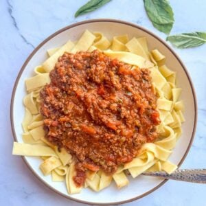 A large bowl of pasta with bison bolognese on top.