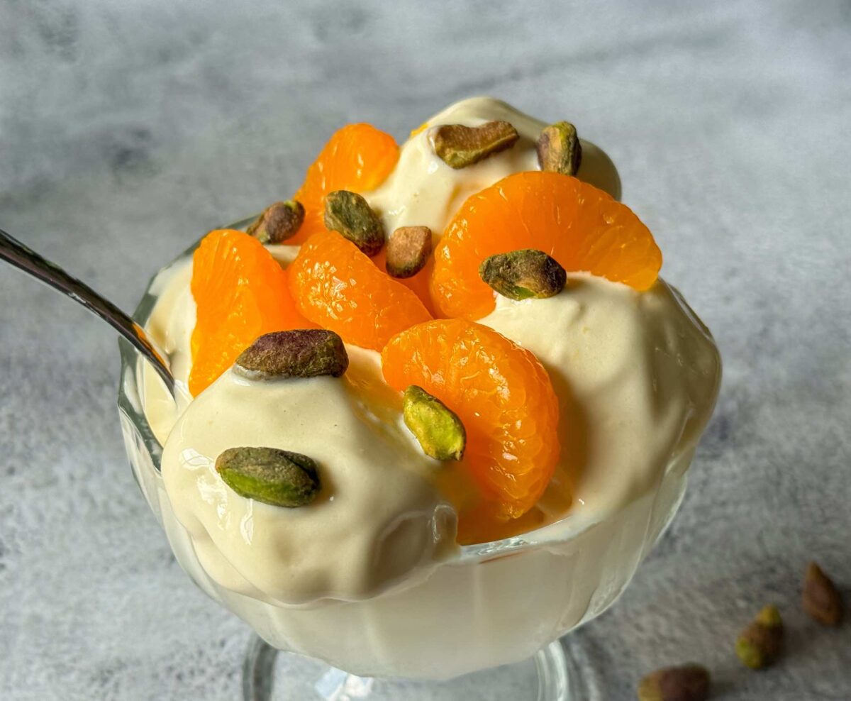 This is an ice cream dish with the orange creamsicle Ninja Creami garnished with mandarin oranges and pistachios.