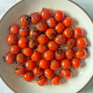 White plate of blistered tomatoes.