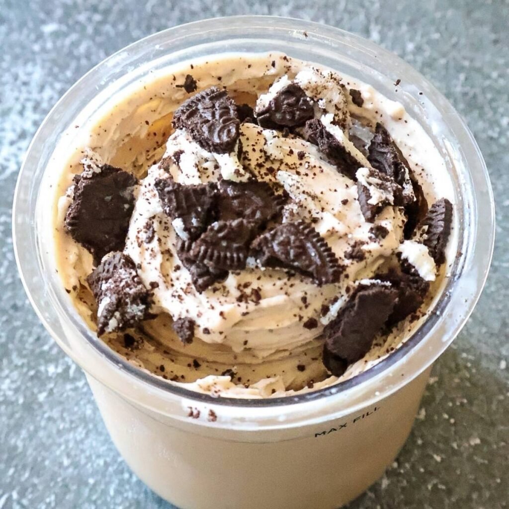 A ninja creami pint container of ice cream topped with crushed oreos.