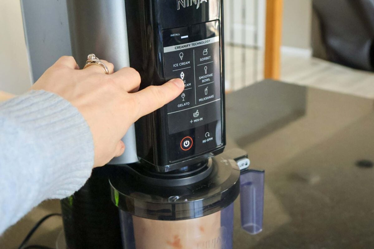 Pressing the lite ice cream button on the Ninja Creami control panel.