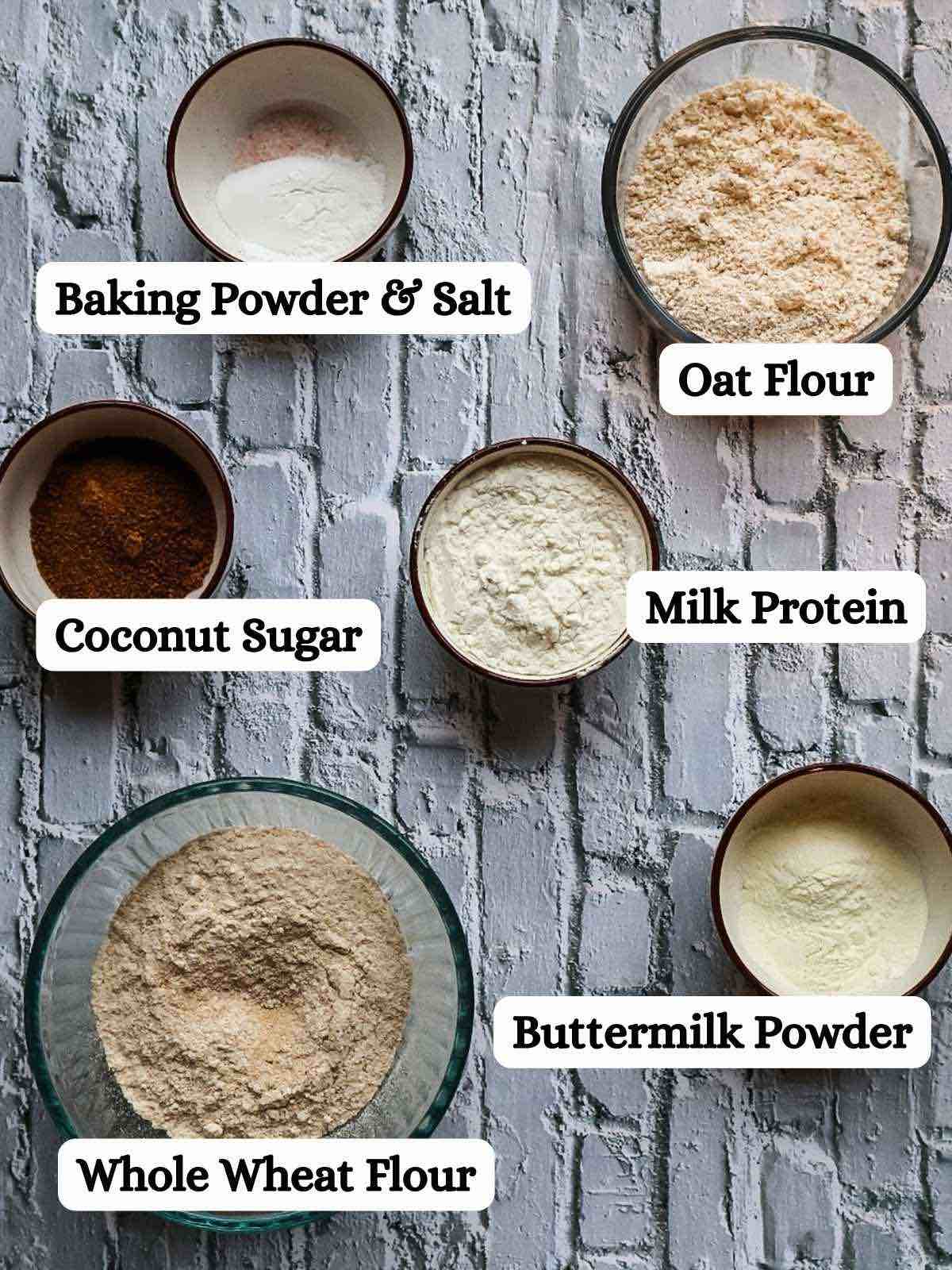 Assorted kodiak copycat recipe ingredients in bowls on white brick background.