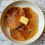 homemade protein pancake mix with syrup and butter on a white plate.