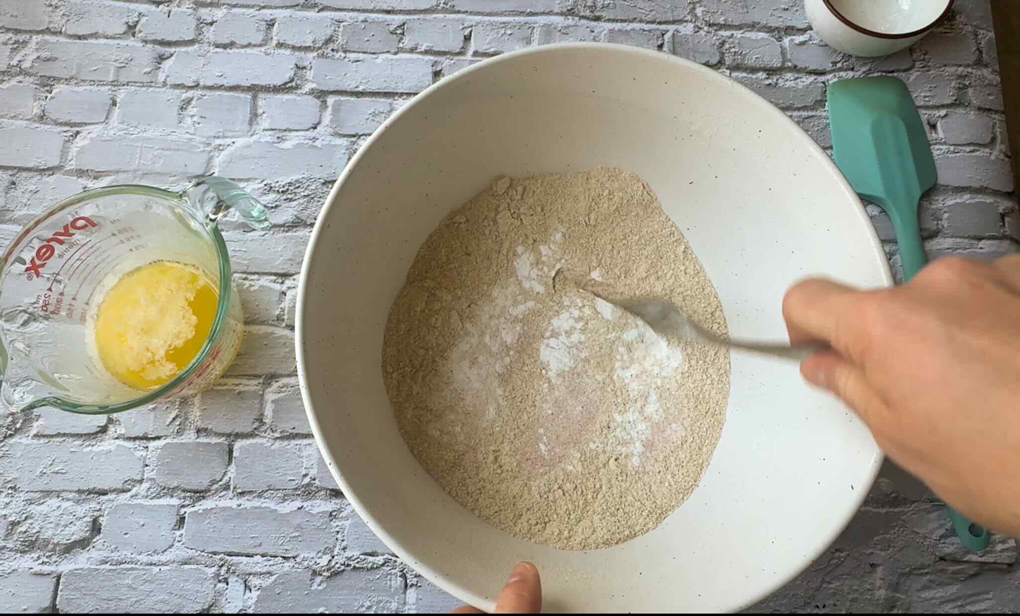 bowl of whole wheat flour with baking powder and salt being mixed in.