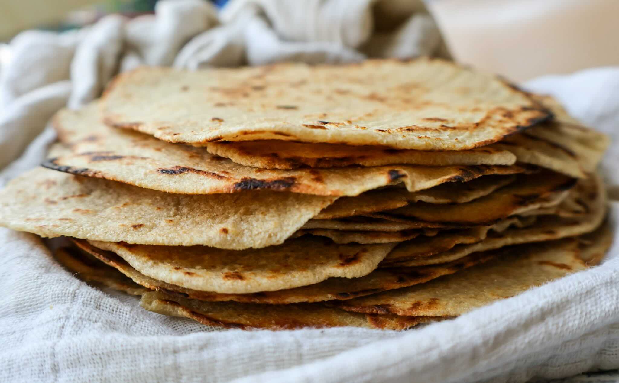 a stack of whole wheat tortillas in a towel.