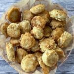 wire basket with homemade healthy chicken nuggets with gray wood background.