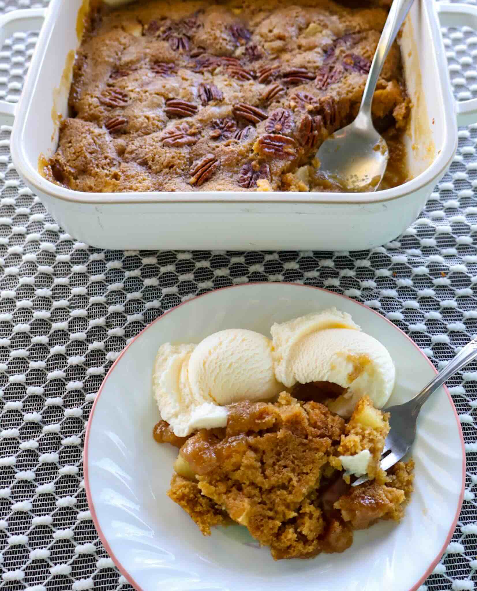 A serving of apple cake with ice cream.