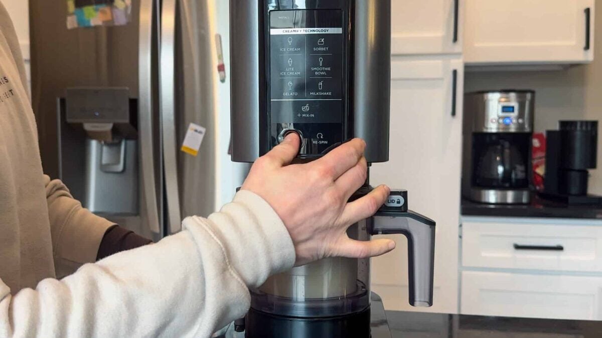 This is a person pressing the power button on the Ninja Creami control panel.